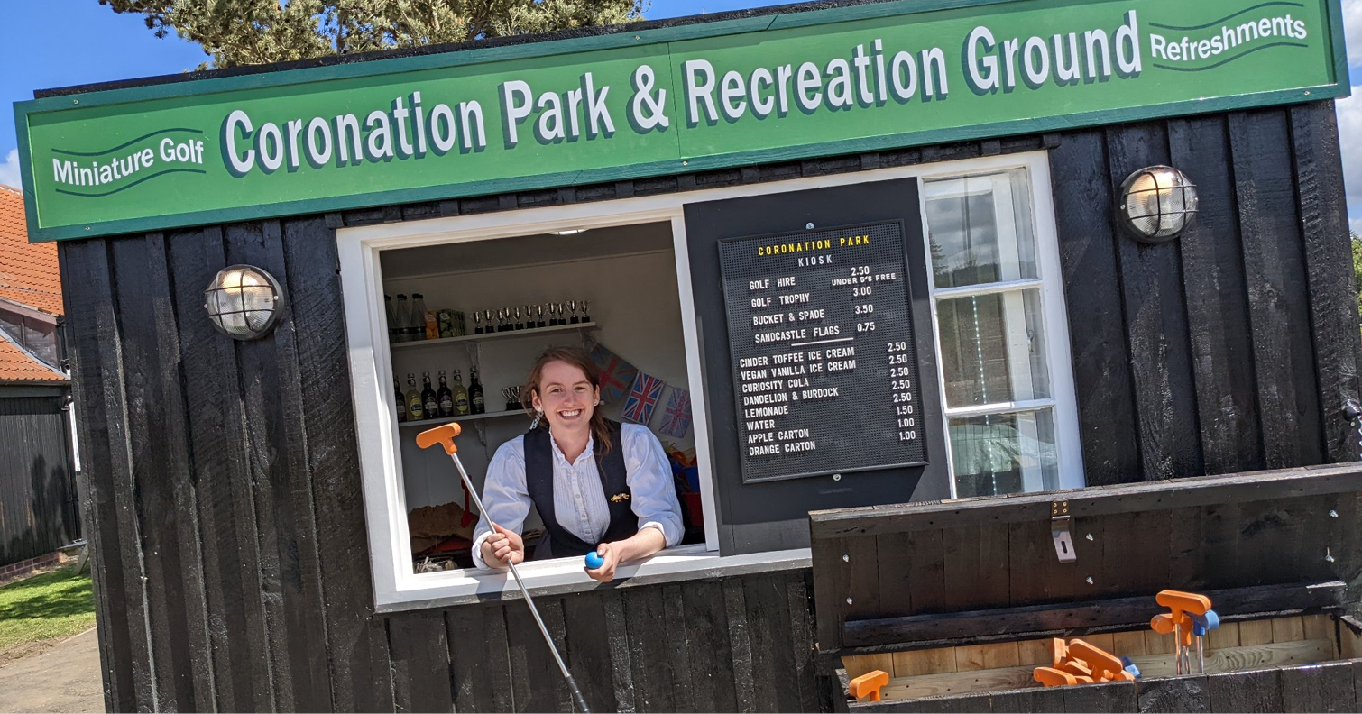 woman smiling at camera from kiosk at Coronation Park, Beamish Museum